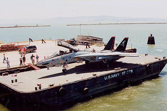 F-14A_05.jpg - F-14A having flown into SFO was then barged across the Bay to Pier 3 where the Hornet is berthed. The Tomcat, a two seat, twin engine, variable swept wing aircraft, was the Navy's primary air superiority fighter, fleet defense interceptor and tactical reconnaissance platorm from 1974 to 2006. Developed after the F-111B was scrubbed and was the first of several teen series fighters designed based on the experience gained against MIGs during the Vietnam War. It replaced the venerable F-4 Phantom and was itself replaced by the F/A-18E/F Super Hornet.